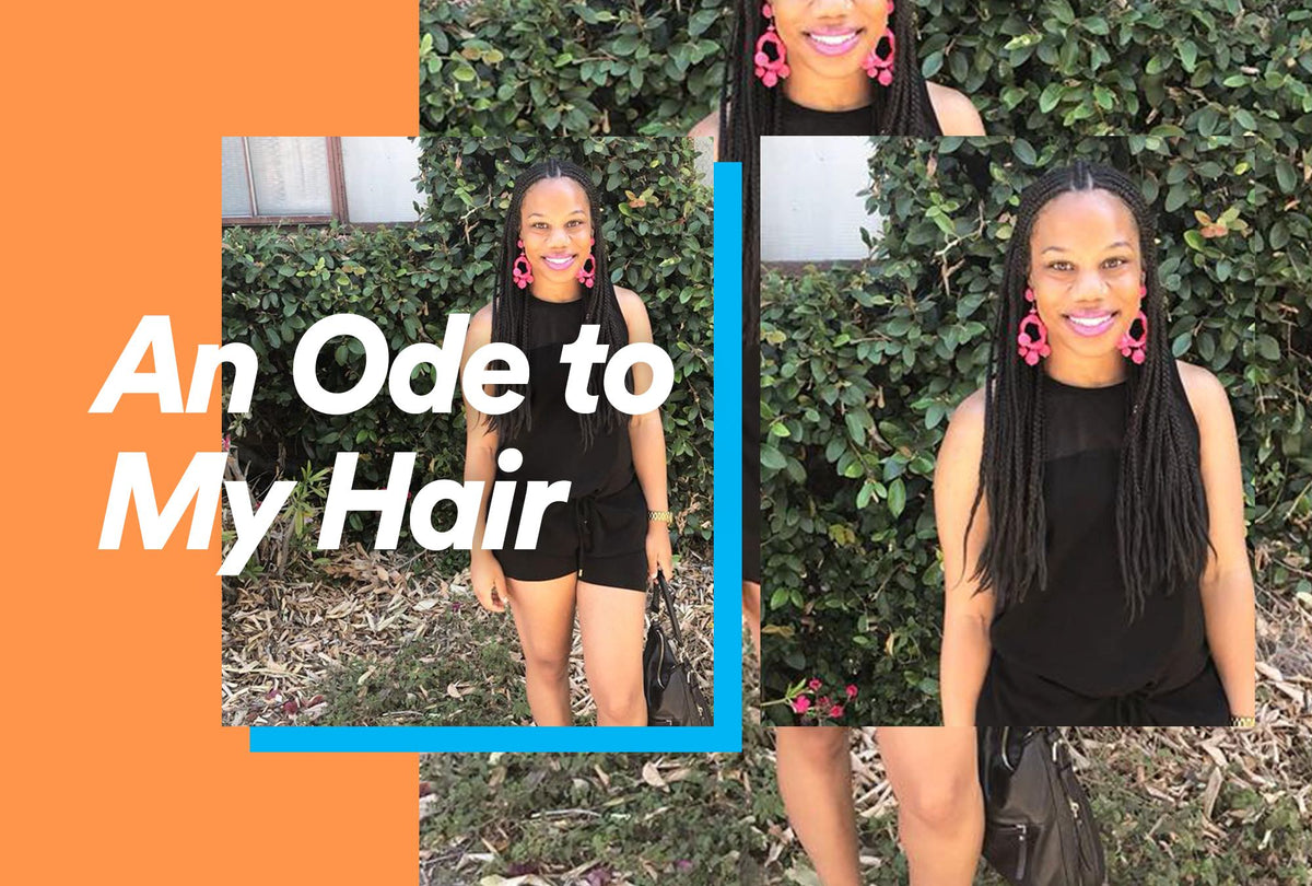 Black woman running her fingers through her natural hair in soft light
