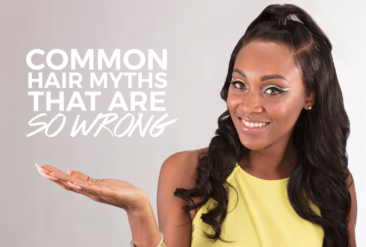 Black woman examining her hair while common hair care myths are debunked