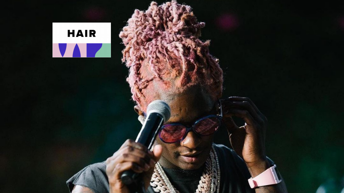 Rapper wearing cornrow braids styled straight back on stage