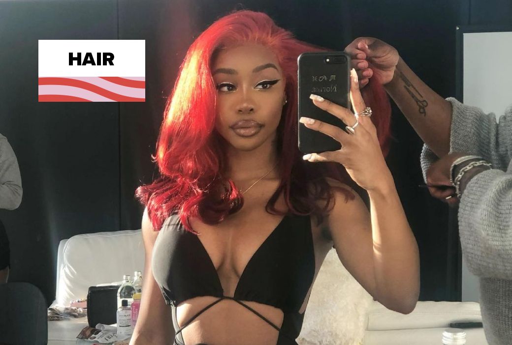 SZA wearing long textured hair styled for a performance