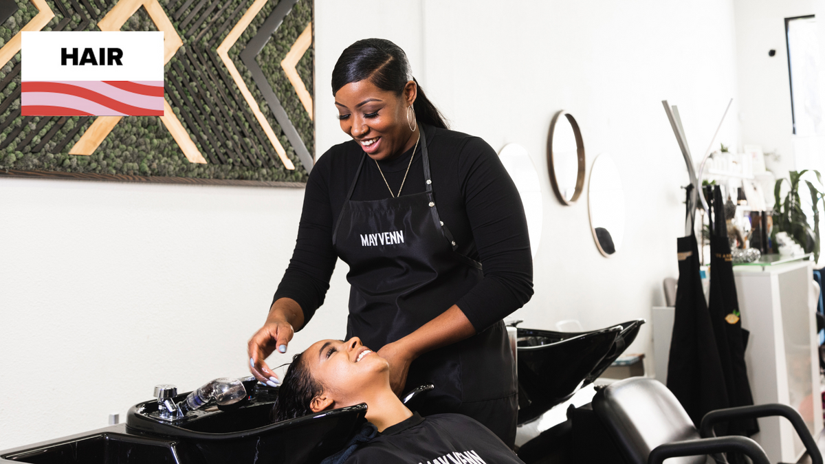 Client handing a tip to her stylist at the salon front desk