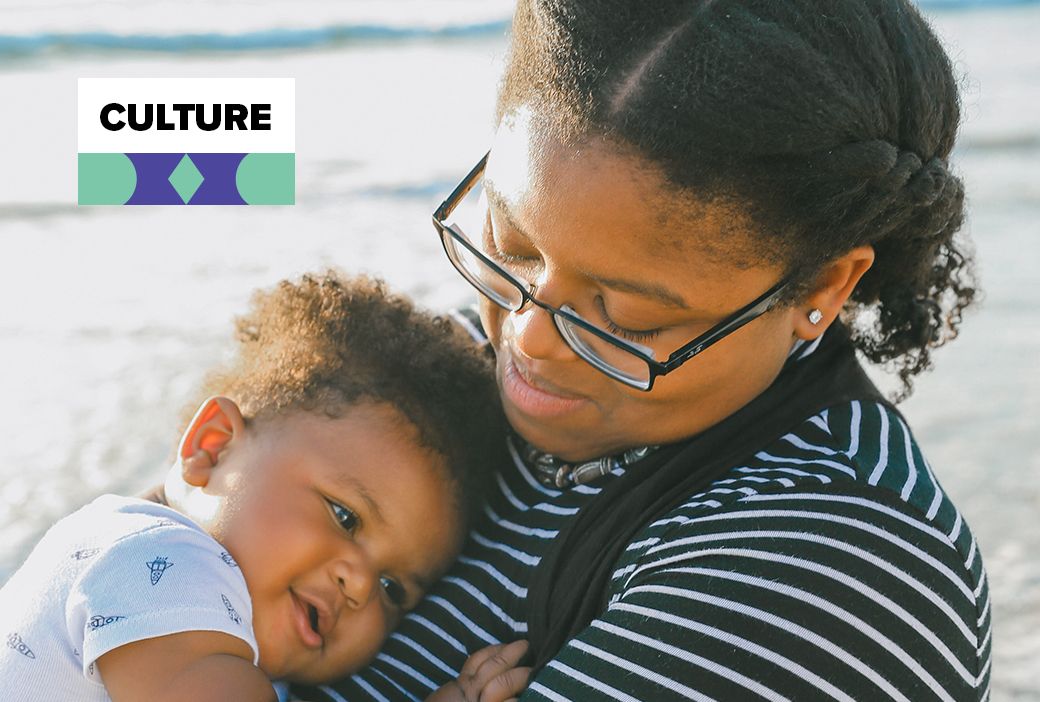 Single Black mother holding her young child at home