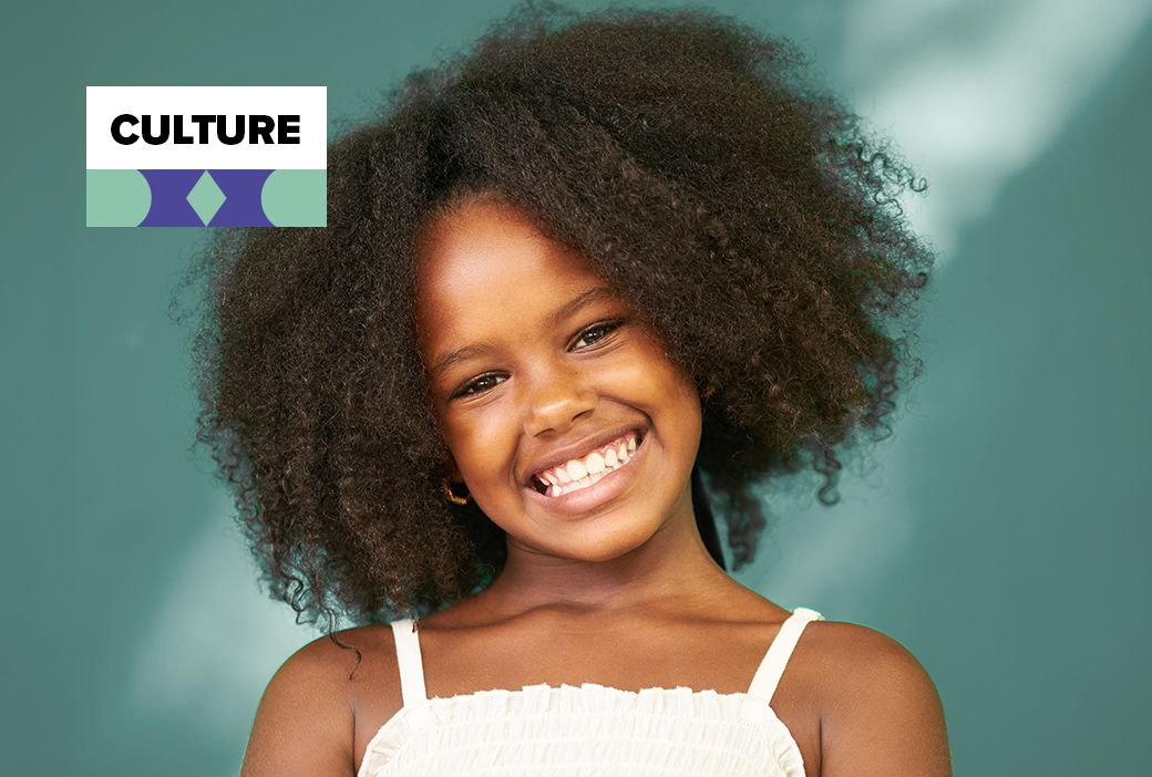 Young Black girl smiling with her natural hair styled in twists