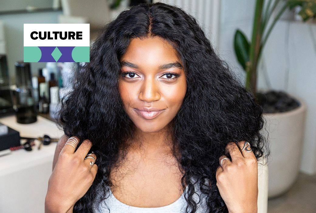 Black woman relaxing while a stylist works through her hair in a salon