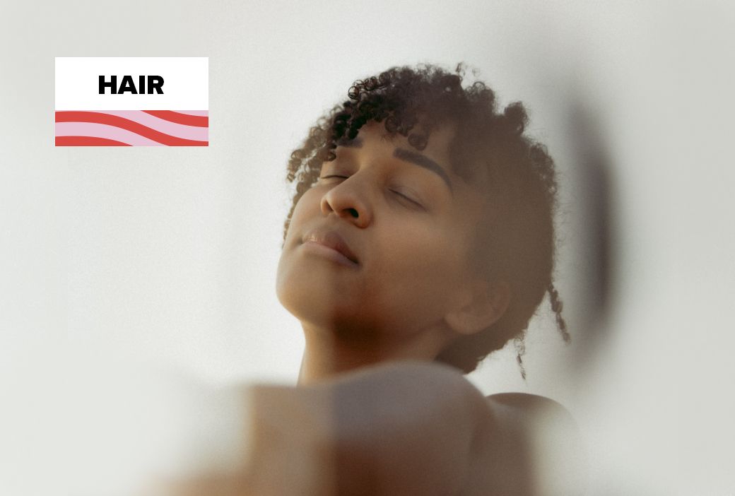 Black woman deep conditioning her natural hair as a self-care ritual