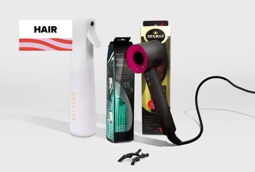Wide tooth comb, denman brush and clips laid out as hair tools