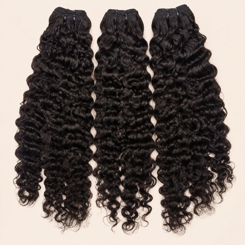 Three Burmese curly human hair bundles standing side by side