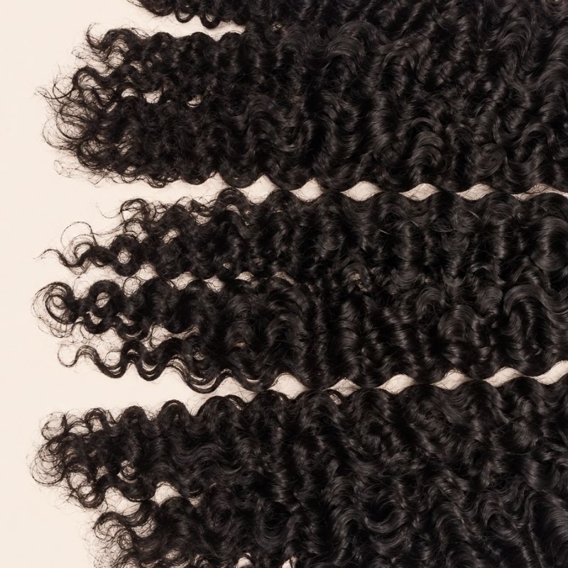 Three Burmese curly wefts laid flat, showing the staggered lengths