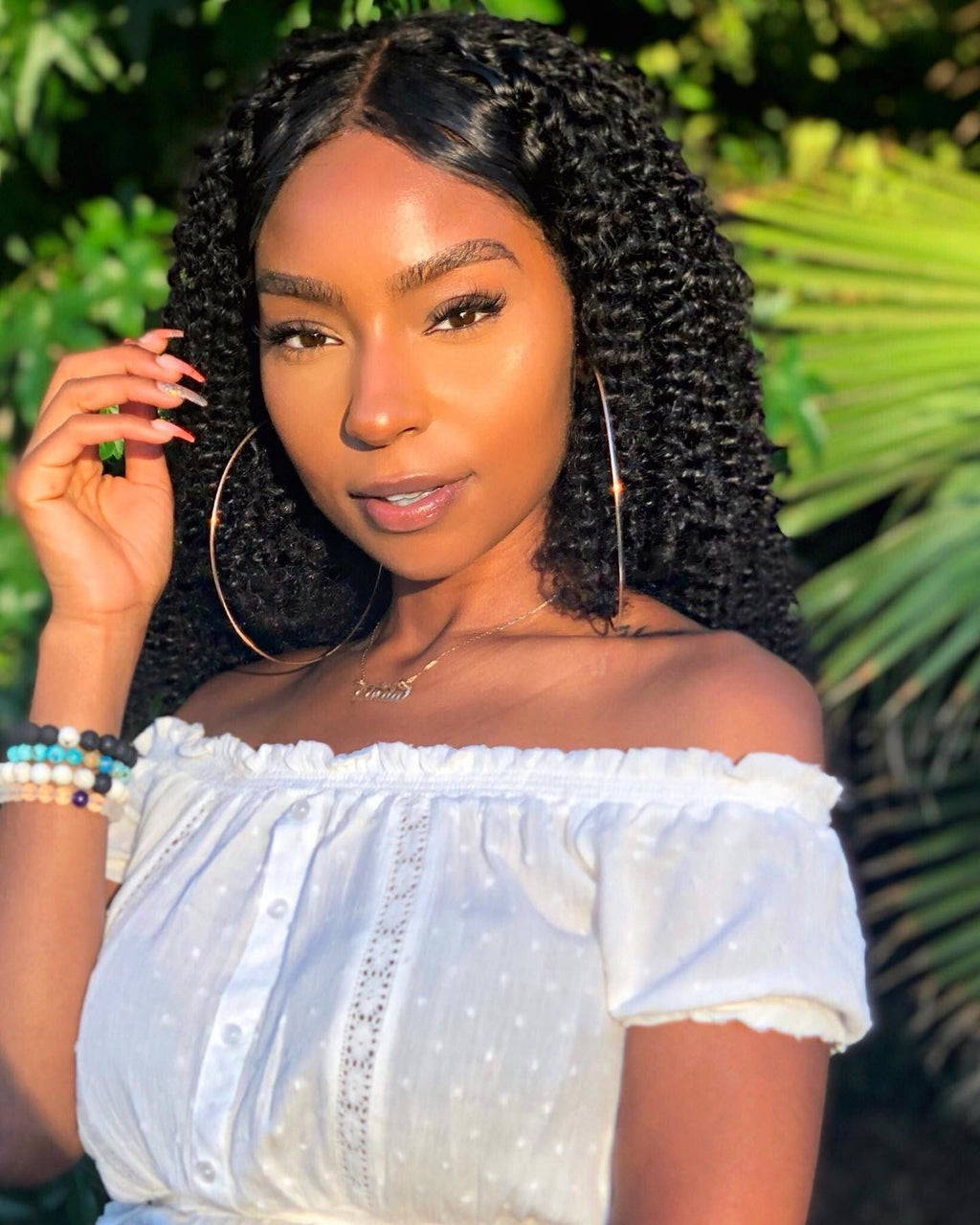 Model wearing a natural black Brazilian curly sew-in, front view
