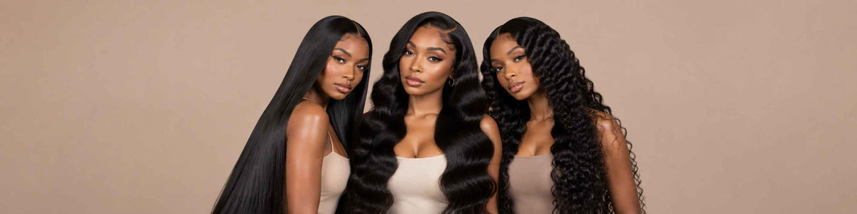 Three women modeling long, dark hair extensions or wigs against a plain beige studio background. The left model has straight black hair, the center model has voluminous loose waves, and the right model has tight curls.