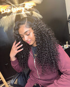 Model smiling in a natural black Brazilian deep wave sew-in, three quarter view