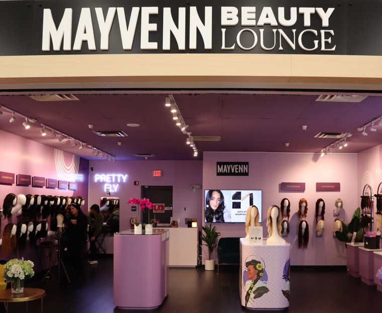 The Mayvenn Beauty Lounge retail counter, wigs on display beneath the Mayvenn Lounge sign