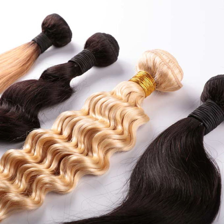 Bundles of virgin human hair laid out, straight and wavy textures