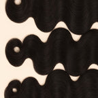Three raw body wave wefts laid flat, showing the staggered lengths