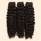 Three raw Burmese curly human hair bundles standing side by side