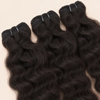 Three raw Indian curly bundles angled to show the machine-sewn wefts