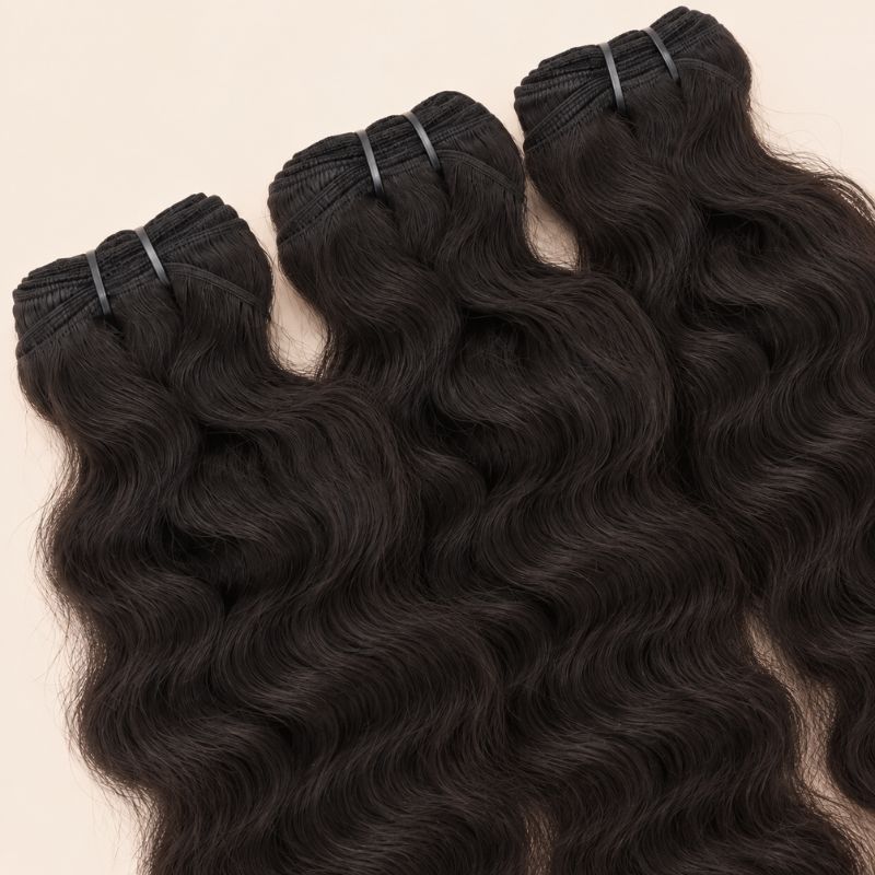 Three raw Indian curly bundles angled to show the machine-sewn wefts