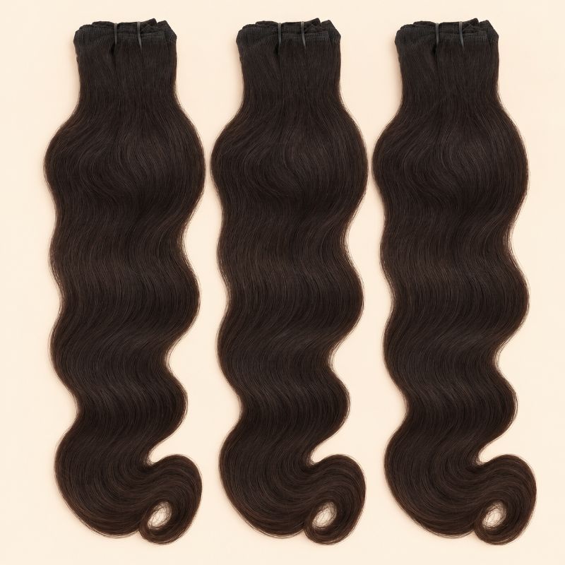 Three raw Indian wavy human hair bundles standing side by side