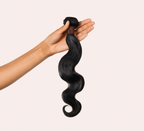 Side view of a jet black body wave install past the shoulder