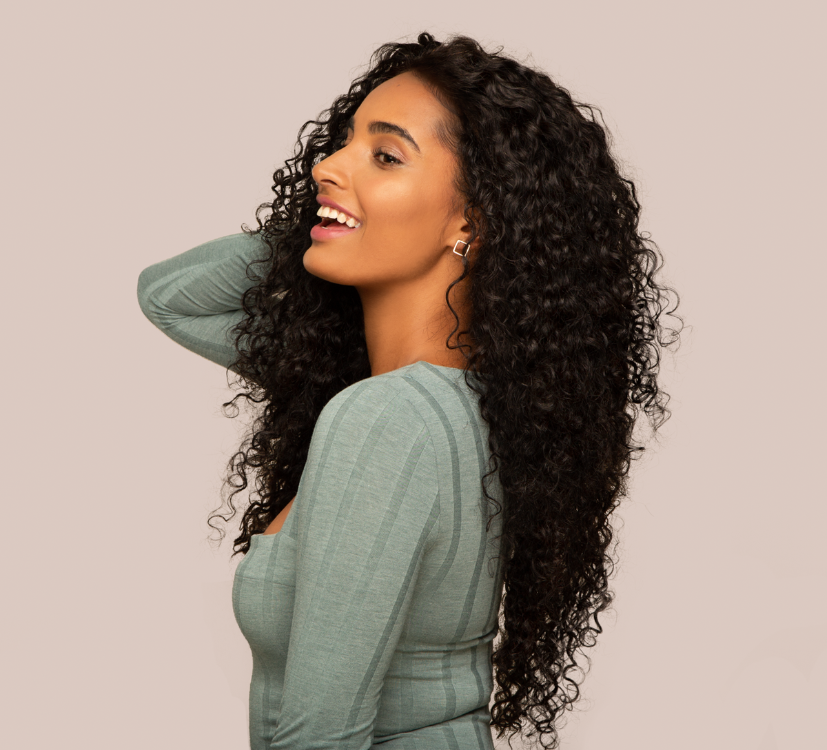 Hand holding a natural black Brazilian water wave bundle to show weft quality