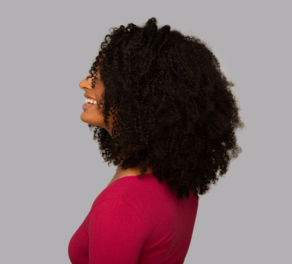 Back view of a Brazilian curly sew-in showing volume and curl definition