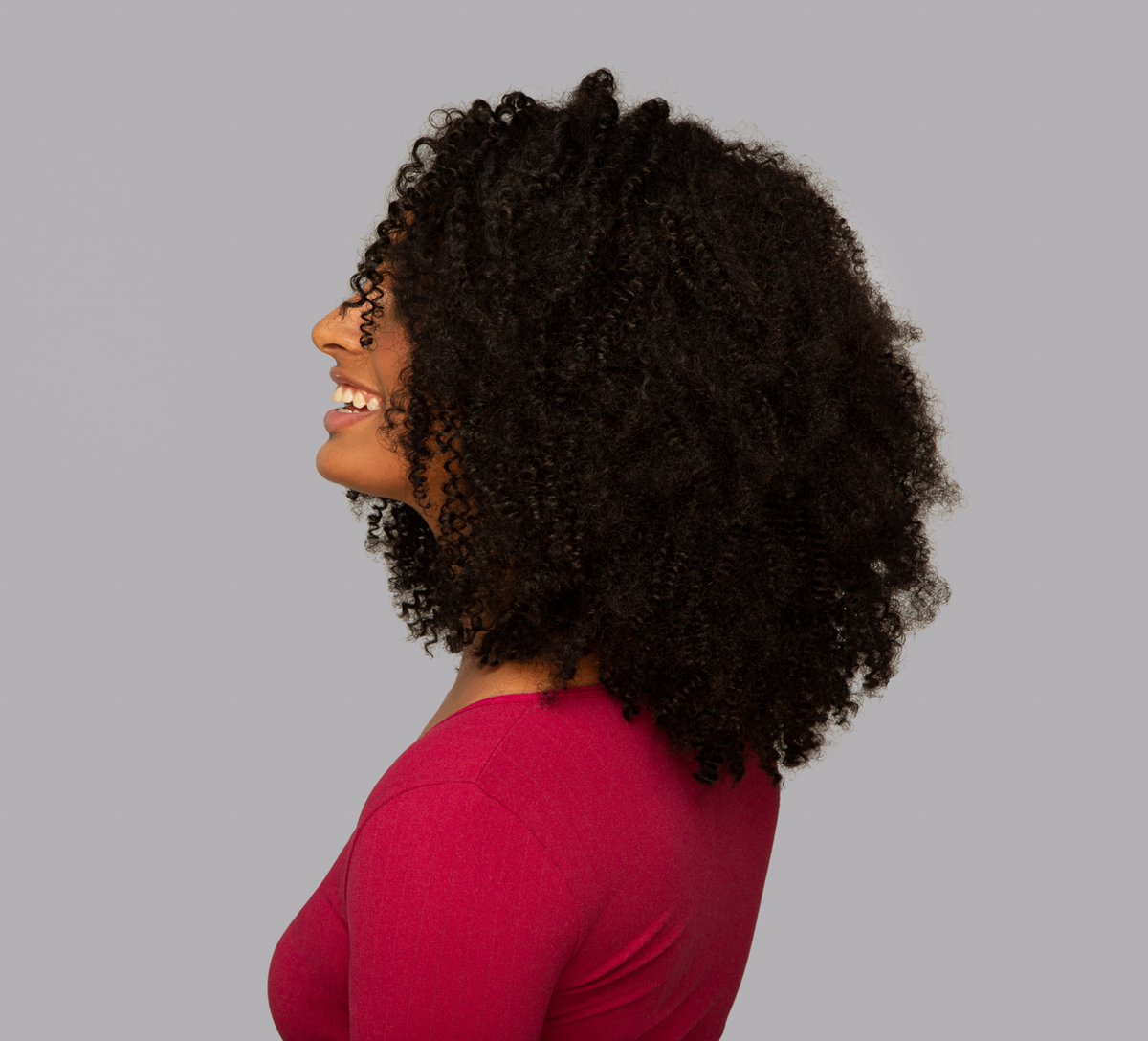 Back view of a Brazilian curly sew-in showing volume and curl definition