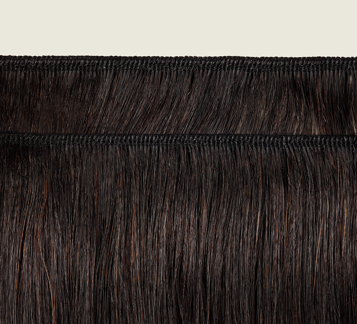 Natural black Brazilian yaki straight bundle coiled on a plain background