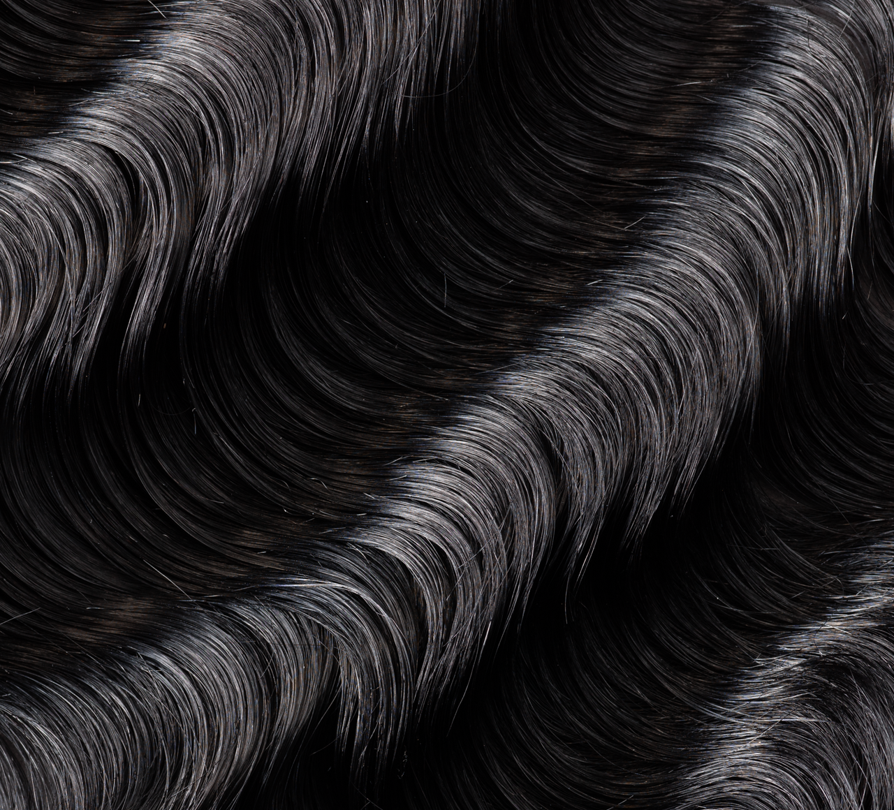 Back view of a jet black loose wave sew-in showing soft movement