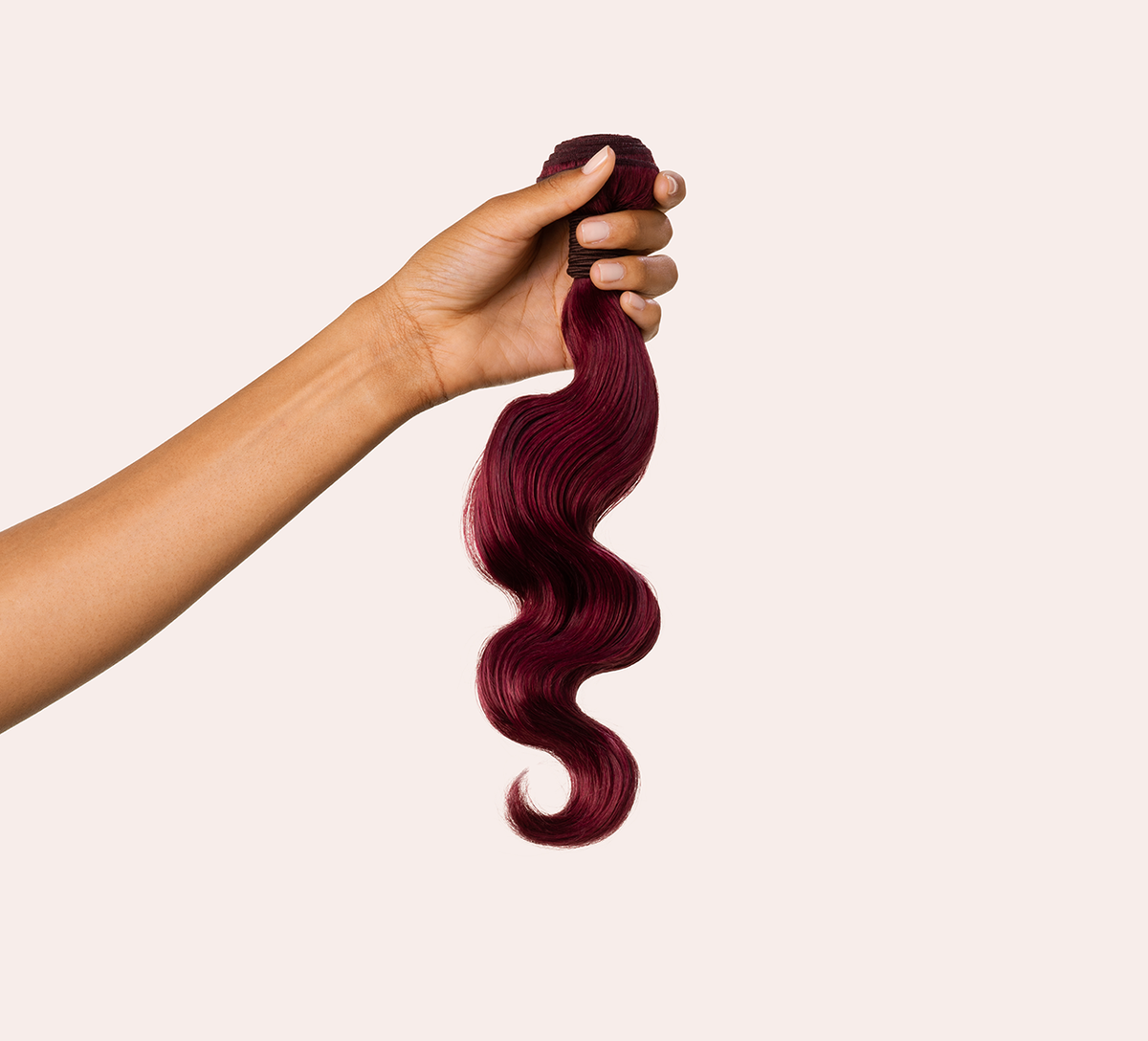 Close-up of the body wave pattern on vibrant burgundy virgin hair