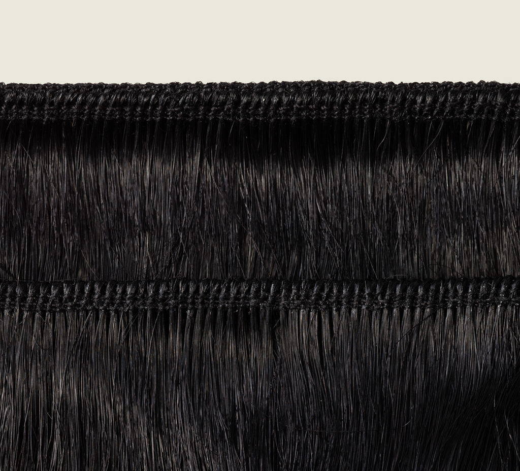 Back view of a jet black body wave sew-in showing bounce and shine