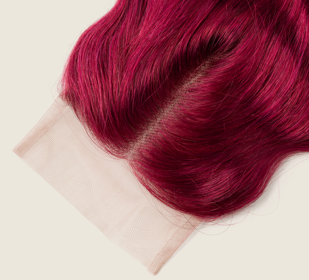 Close-up of the HD lace parting on a burgundy body wave closure