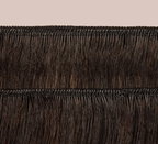 Natural black Brazilian curly bundle coiled on a plain background
