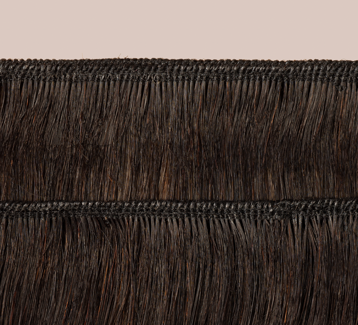 Natural black Brazilian curly bundle coiled on a plain background