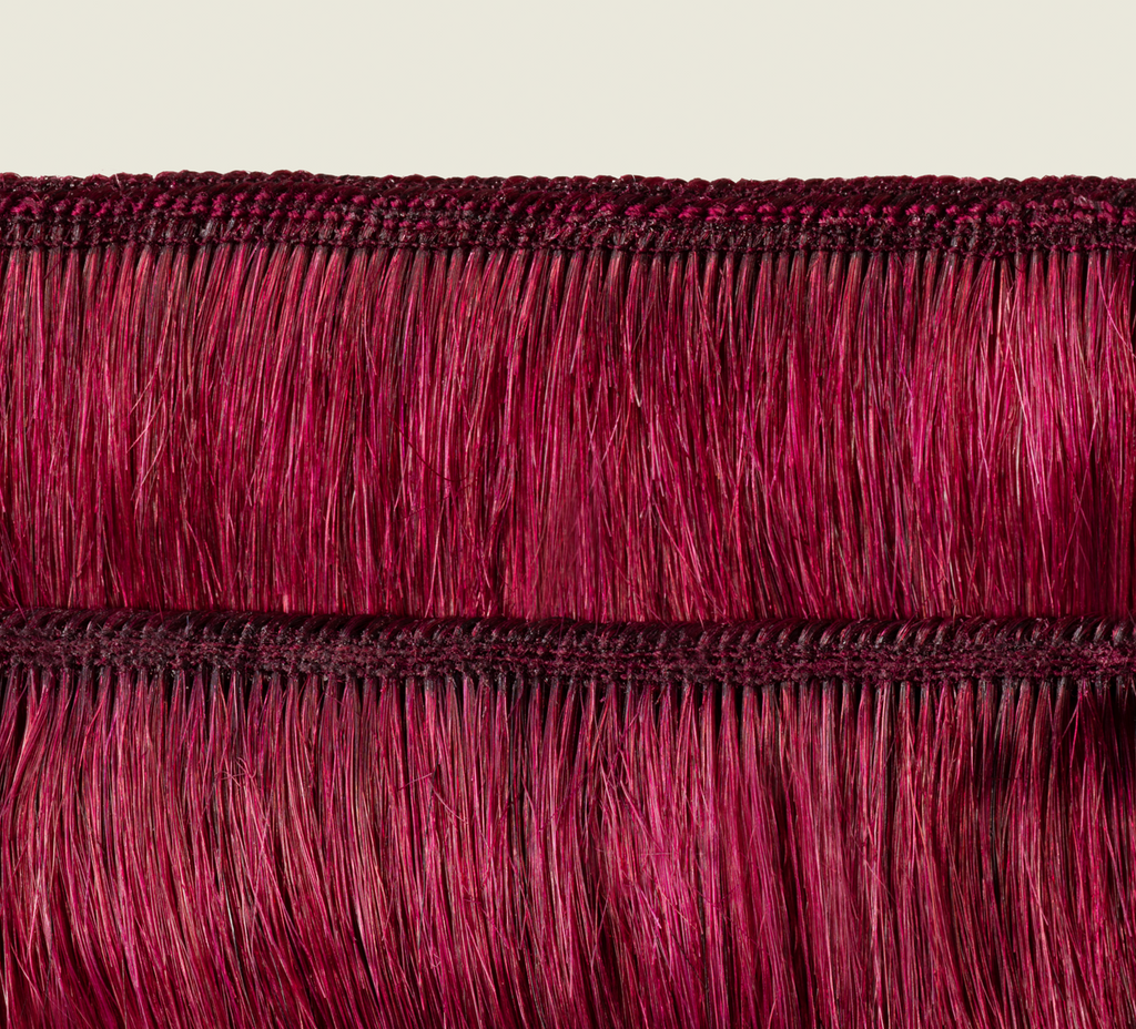 Side view of a burgundy body wave install past the shoulder