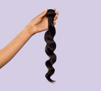 Side view of a natural black Brazilian loose wave install past the shoulder