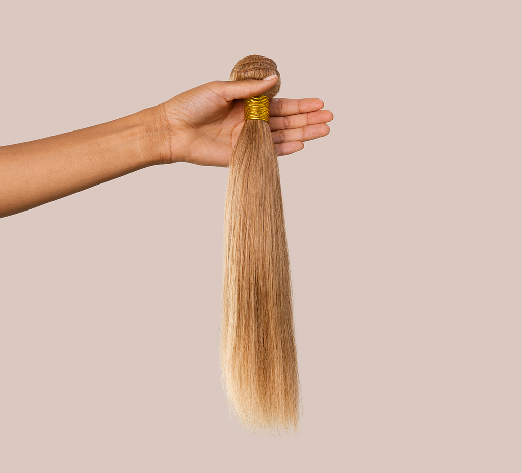 Close-up of the double machine weft on a honey blonde straight bundle