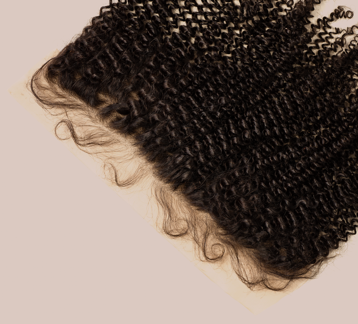Close-up of transparent lace and coils along a curly frontal hairline