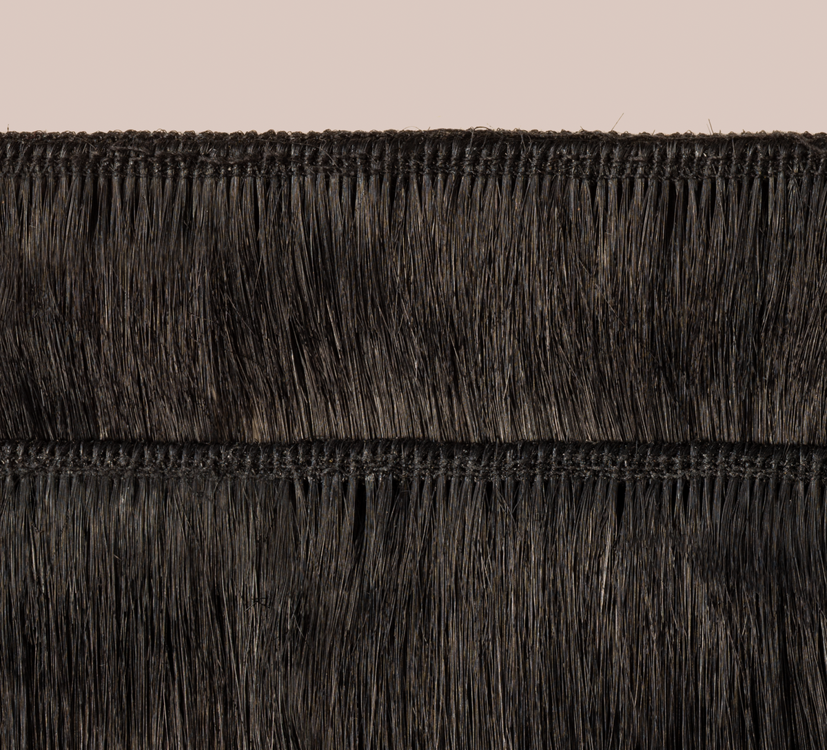 Side view of a jet black loose wave install past the shoulder